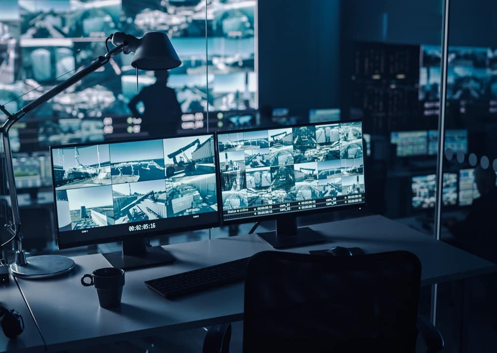 Two Digital Computer Screens with Surveillance CCTV Video in a Harbour Monitoring Center with Multiple Cameras on a Big Digital Screen. Employees Sit in Front of Displays with Big Data